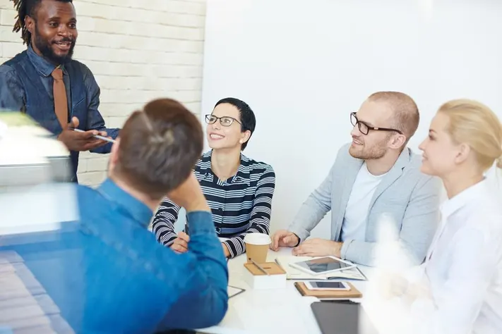A clean photo of a presenter pitching to a small panel or audience in a modern space